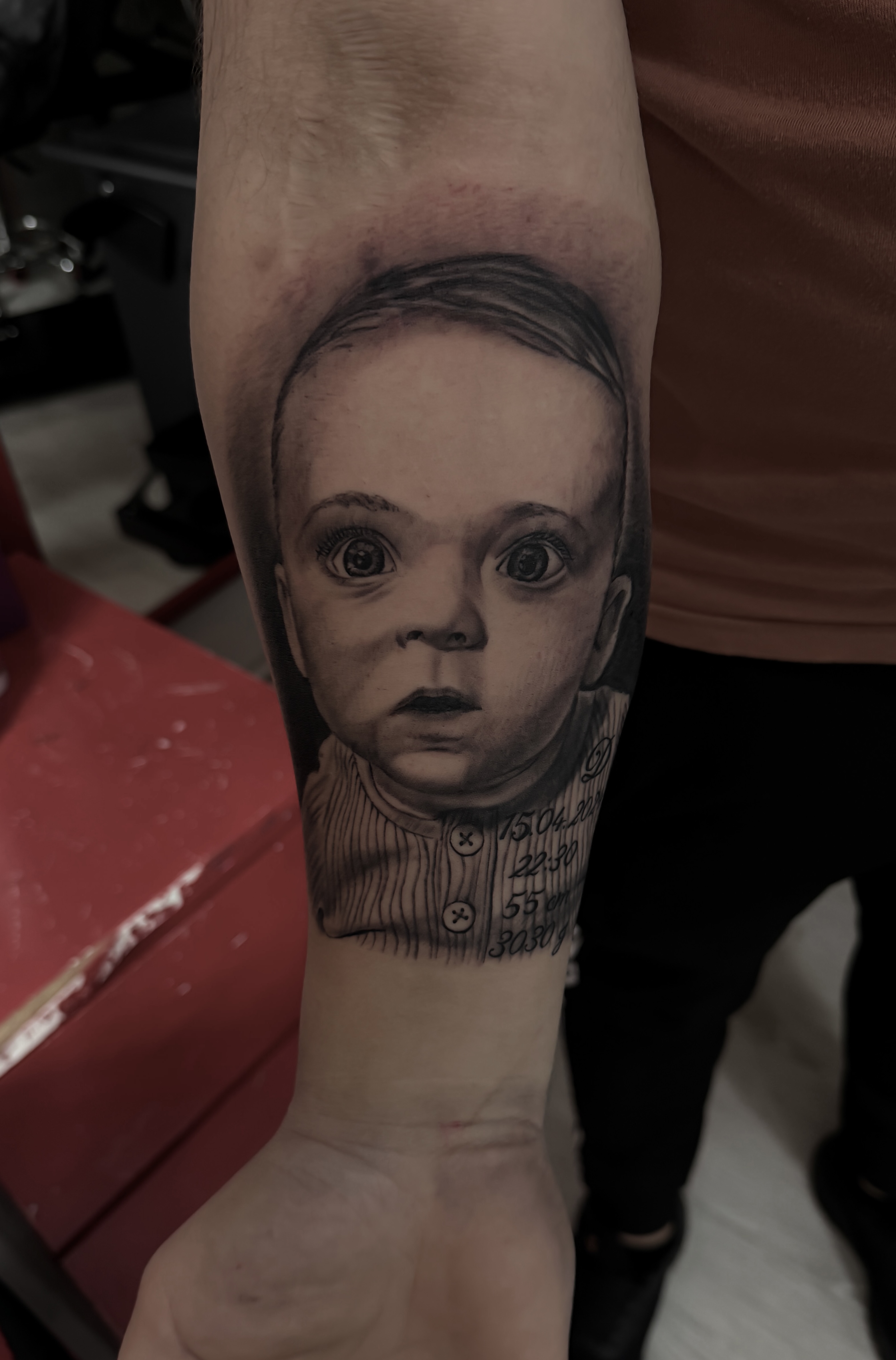 Portret de copil tatuat în stil black & grey pe antebraț