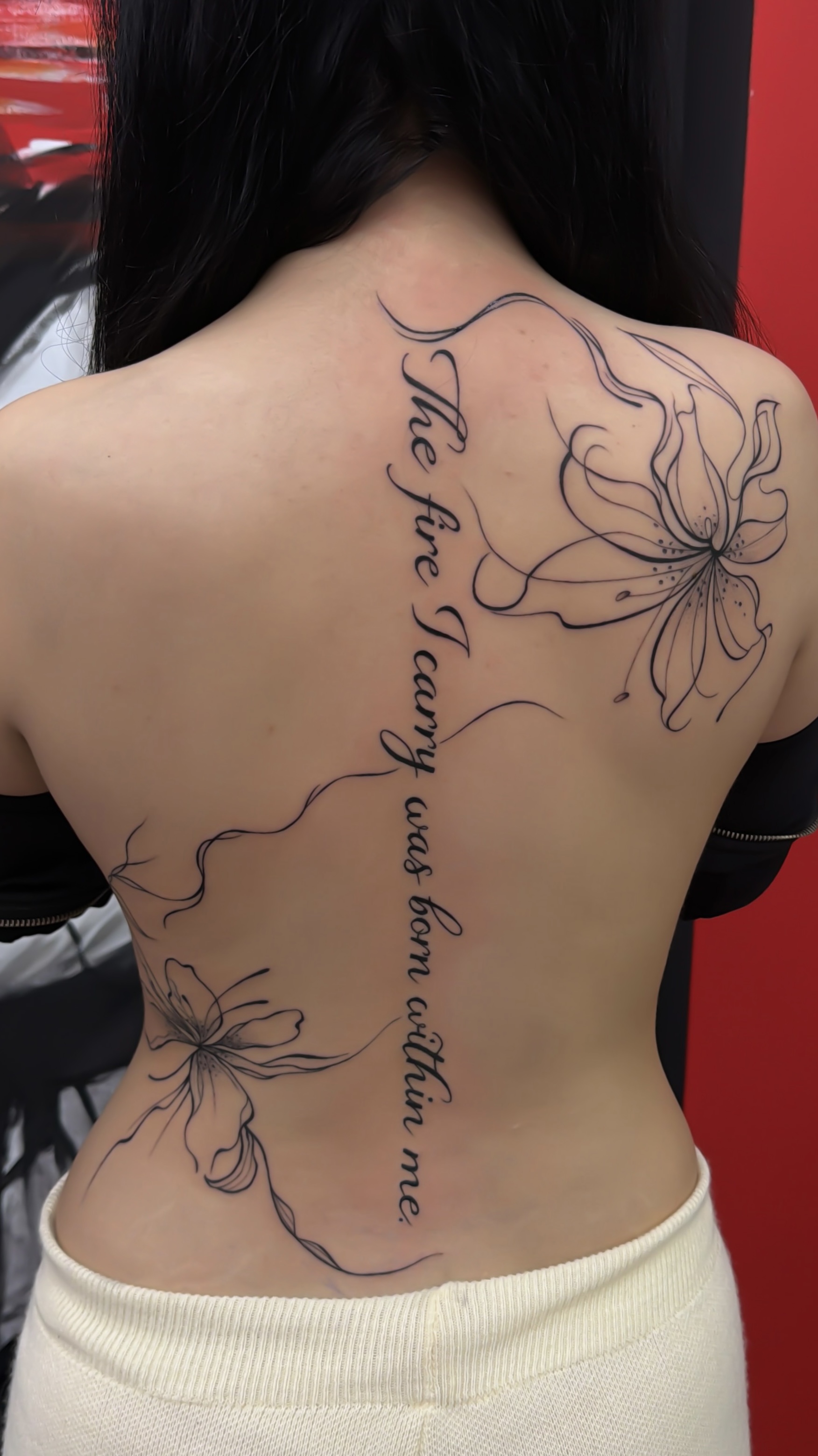 Tatuaj fine line cu flori și text pe spate