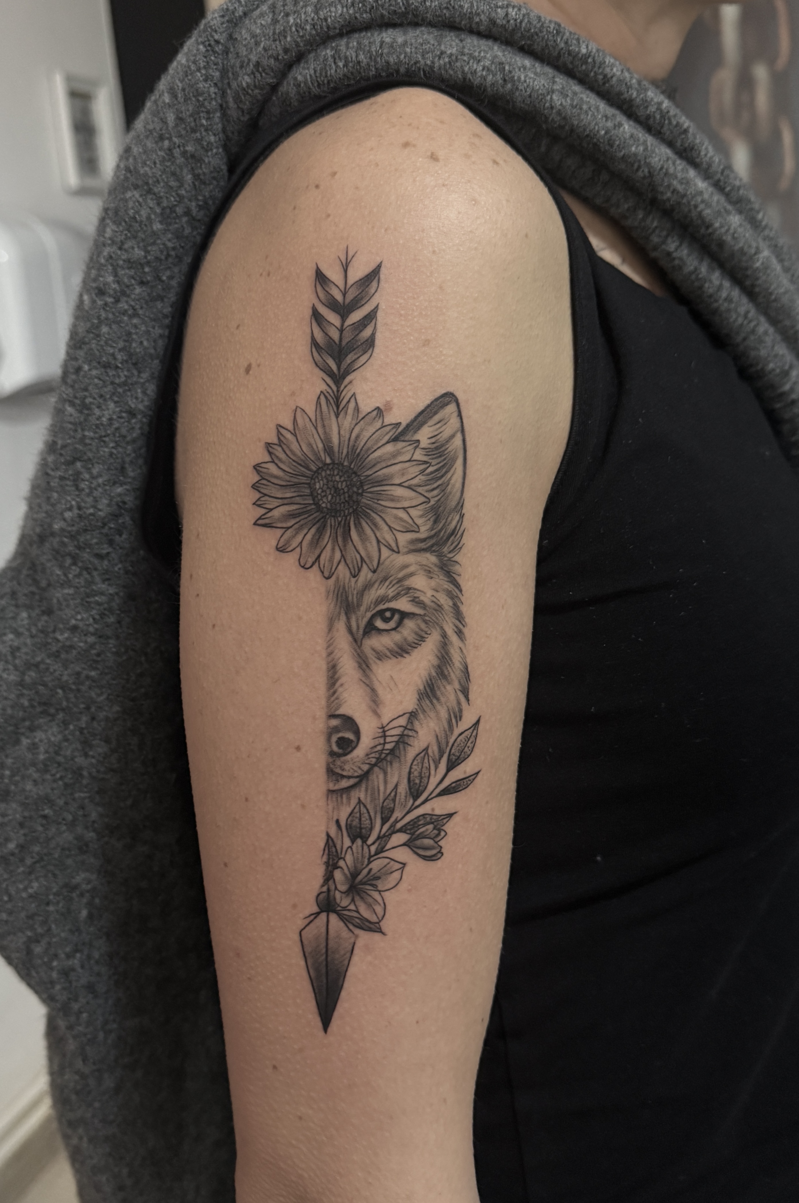 Tatuaj pe braț cu lup, flori și săgeată